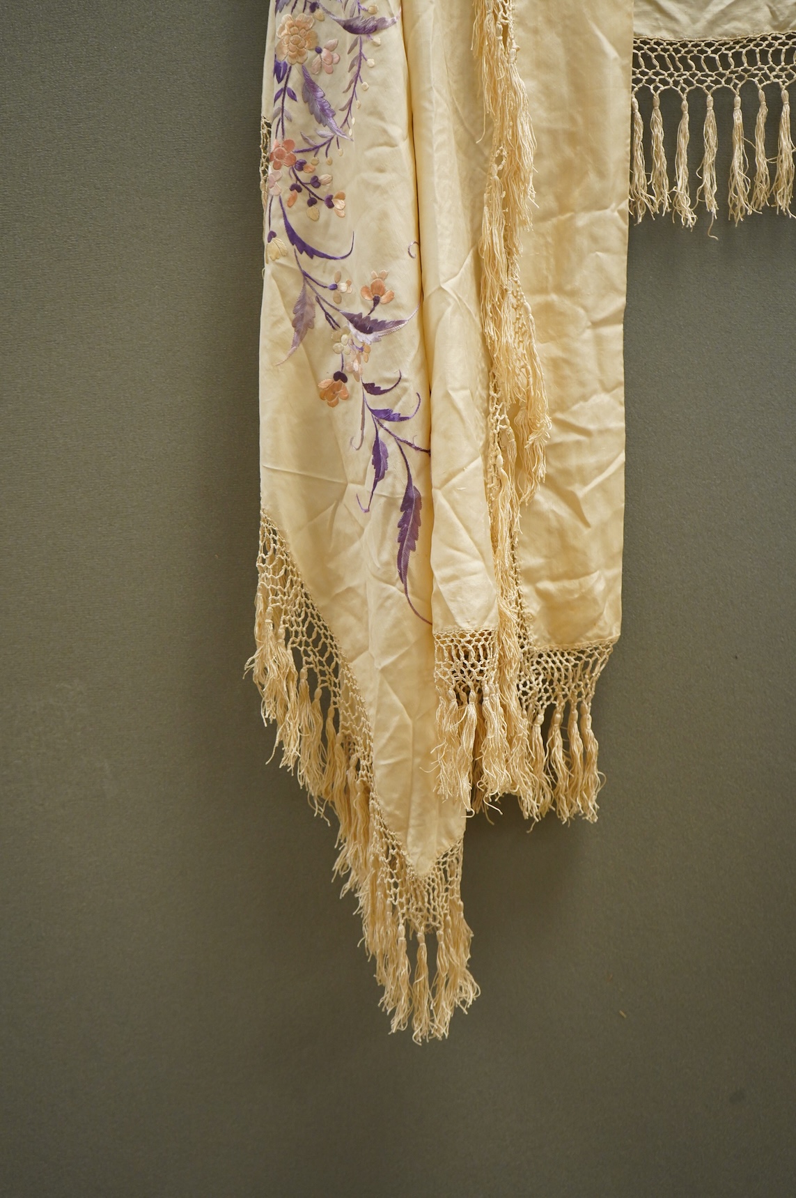 A 19th century Chinese cream silk embroidered and fringed stole, converted to a cape. Embroidered in pastel pinks and lilacs.192cm long